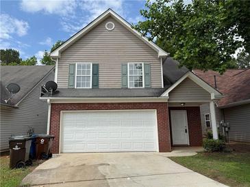 Two-story home with neutral siding, brick accents, and a two-car garage at 1720 New Orleans Way, Mcdonough, GA 30252