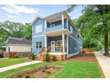 Charming two-story home featuring a covered porch, landscaped yard, and light blue siding at 73 Whitefoord Se Ave, Atlanta, GA 30317