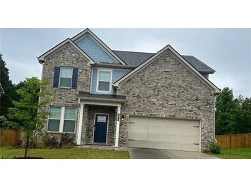 Charming two-story brick home featuring a covered entrance, attached garage and manicured lawn at 2837 Malton Way, Loganville, GA 30052