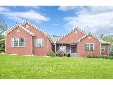 Charming single-story brick home with a manicured front lawn and a welcoming porch at 516 Main St, Hiram, GA 30141