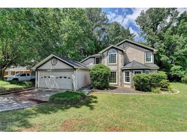 Charming traditional home featuring a two-car garage, manicured lawn, mature trees, and lots of curb appeal at 1464 Yorktown Nw Dr, Lawrenceville, GA 30043