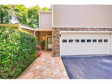 Charming home exterior with stone accents, a well-manicured lawn and an attached two car garage at 41 Basswood Cir, Sandy Springs, GA 30328