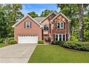 Charming two-story brick home with manicured lawn and a two-car garage, perfect for suburban living at 963 Hawk Creek Trl, Lawrenceville, GA 30043