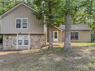 Charming two-story home with stone accents and a cozy front entrance, surrounded by mature trees at 5334 Post Road Pass, Stone Mountain, GA 30088
