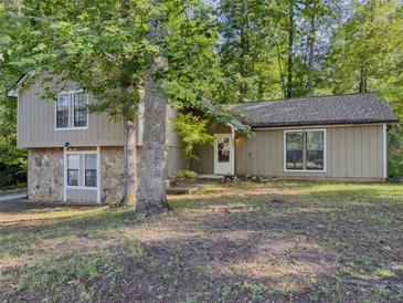 Charming home featuring stone accents, neutral paint, and a welcoming front entrance, nestled among mature trees at 5334 Post Road Pass, Stone Mountain, GA 30088