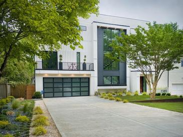 Modern home with a black framed garage door, second story balcony, and neatly landscaped front yard at 2385 Nesbitt Dr, Brookhaven, GA 30319