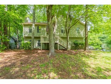 Two-story home surrounded by mature trees and lush greenery, offering a private and serene setting at 6015 Sumit Nw Ct, Kennesaw, GA 30152