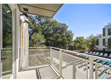 A balcony overlooks a pool and green trees on a sunny day at 775 Juniper Ne St # 334, Atlanta, GA 30308