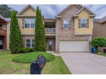 Charming two-story home featuring a stone facade, attached two-car garage and a well-manicured lawn at 3399 Lake Frg, Fairburn, GA 30213