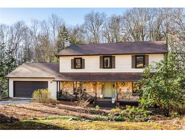 Charming two-story home features stone accents, a covered porch with wood railings, and a well-maintained front yard at 4568 Oswood Ct, Tucker, GA 30084