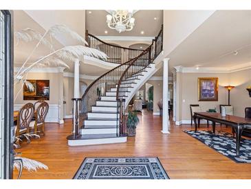 Elegant foyer with a winding staircase, hardwood floors, and a decorative chandelier creates a grand entrance at 2502 Oak Hill Ovlk, Duluth, GA 30097