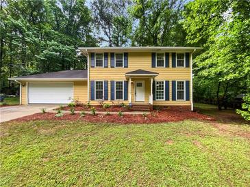 Charming two-story home with yellow siding, dark shutters, and a well-manicured lawn at 8683 Twin Oaks Dr, Jonesboro, GA 30236