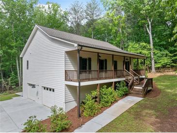 Charming, elevated home featuring a covered porch, two car garage and wooded surroundings at 210 Joe Green Ln, Canton, GA 30114