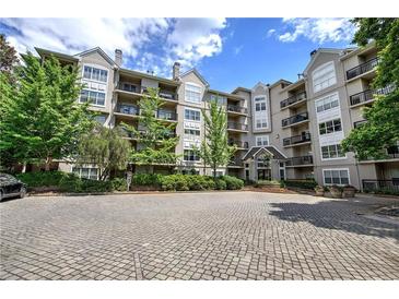 Beautiful condo building exterior with lush landscaping, balconies, and a paved parking area at 2110 River Green Nw Dr # 2110, Atlanta, GA 30327