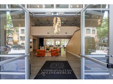 A grand lobby with high ceilings, a modern chandelier, and a cozy seating area creates a welcoming atmosphere at 711 Cosmopolitan Ne Dr # 338, Atlanta, GA 30324