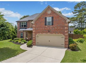 Beautiful two-story brick home with a well-manicured lawn and two car garage at 2430 Tack Hill Ct, Dacula, GA 30019
