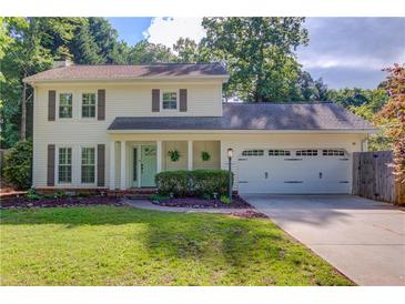 Charming two-story home featuring a well-manicured lawn, two-car garage, and classic curb appeal at 6006 Lanier Heights Cir, Buford, GA 30518
