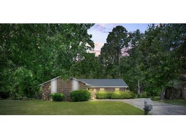 Brick single-story home with manicured lawn, bushes, and a private driveway surrounded by mature trees at 3250 Valley Bend Rd, South Fulton, GA 30349