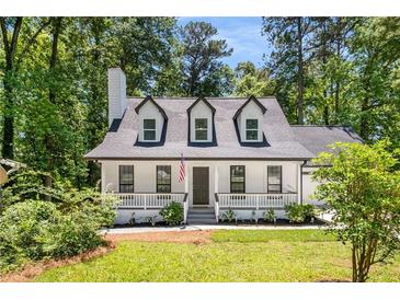 Charming Cape Cod style home featuring dormer windows, a covered front porch, and a landscaped front yard at 944 Pine Ridge Dr, Stone Mountain, GA 30087