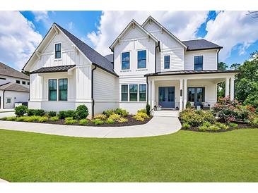 Stunning two-story home featuring a beautifully landscaped yard, covered porch, and classic white siding at 4992 Concert Ln, Marietta, GA 30066