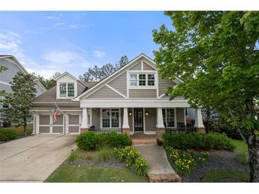 Charming home showcasing a covered front porch, beautiful landscaping, and a two-car garage at 998 Regal Hills Ln, Mableton, GA 30126