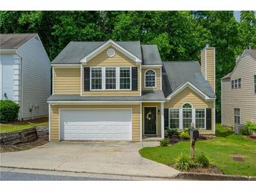 Two-story home featuring a two-car garage, and neutral siding, surrounded by well-maintained landscaping at 3454 Benthollow Ln, Duluth, GA 30096