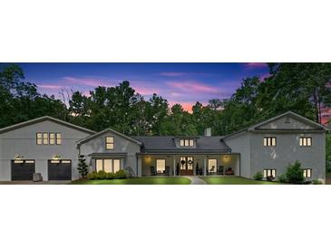 Stunning exterior elevation of home at dusk with meticulous landscaping and charming front porch at 1421 Hendon Rd, Woodstock, GA 30188
