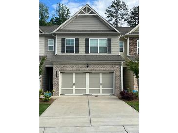 Charming townhome featuring a two-car garage and gray siding with black shutters at 6780 Cedar Glen Rd, Peachtree Corners, GA 30360
