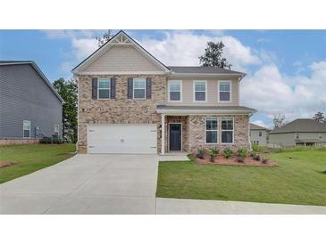 Charming two-story home featuring a brick facade, neutral siding, and an attached two-car garage at 320 Tulip Dr, Covington, GA 30016