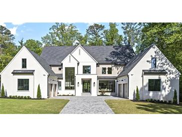 Stunning new construction home with a white brick facade, elegant trim, and a spacious three-car garage at 4785 Merlendale Ct, Atlanta, GA 30327