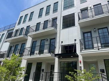Modern townhouse with white brick facade, dark trim, multiple balconies, and professional landscaping at 1276 Longreen Terrace Nw # 115, Atlanta, GA 30318