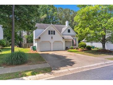 Charming two-story home with a two-car garage and well-maintained landscaping at 141 Weatherstone Dr, Woodstock, GA 30188