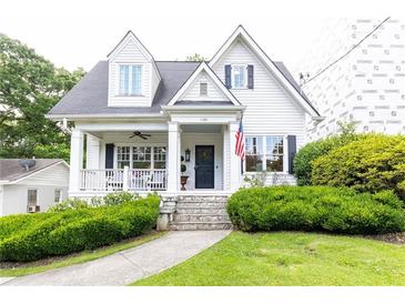 Charming two-story white home with black shutters, covered porch, and landscaped front yard at 1486 Brooklyn Nw Ave, Atlanta, GA 30309
