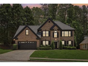 Charming two-story brick home featuring a well-manicured lawn and attached two-car garage at 1045 River Valley Dr, Dacula, GA 30019