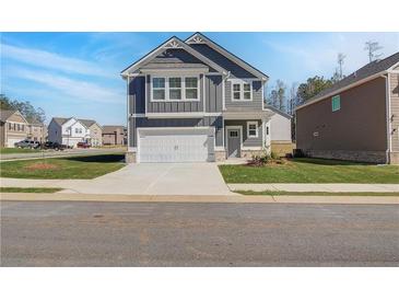 Charming two-story home with gray siding, white trim, and a two-car garage in a suburban neighborhood at 266 Tulip Dr, Covington, GA 30016