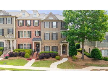 Charming townhome featuring a landscaped front yard and a welcoming entrance with a brick facade and decorative shutters at 3857 Felton Hill Sw Rd # 9, Smyrna, GA 30082