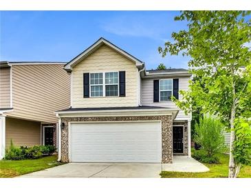 Charming two-story home featuring a two-car garage and a well-maintained front yard with attractive landscaping at 7630 Volion Pkwy, Fairburn, GA 30213