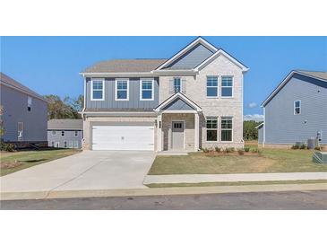 Charming two-story home featuring a two-car garage, manicured lawn, and inviting front porch at 107 St Annes Pl, Covington, GA 30016