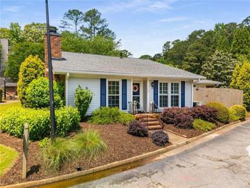 Charming single-story home featuring tidy landscaping and blue shutters on a sunny day at 1140 Moorestown Cir, Decatur, GA 30033