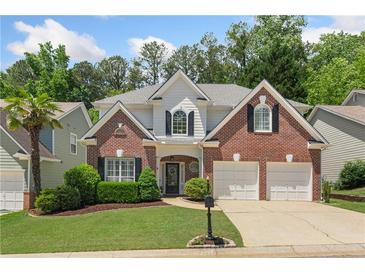 Charming two-story brick home featuring a well-manicured lawn and an attached two-car garage at 4018 Rhyne Se Cir, Smyrna, GA 30082