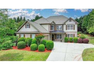 Charming two-story home with manicured lawn, lush landscaping, and a spacious driveway at 3120 Caney Creek Ln, Cumming, GA 30041