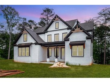 Beautiful white brick home features black trim and a covered front porch at 1072 Sweet Mia Ln, Powder Springs, GA 30127