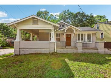 Charming home featuring a covered porch, brick facade, and well-manicured lawn at 1667 Sylvan Sw Rd, Atlanta, GA 30310