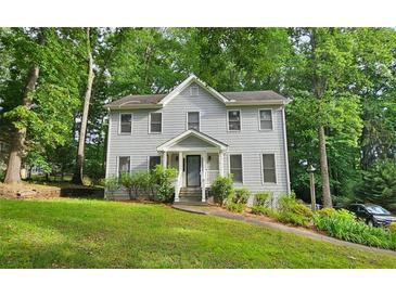 Charming two-story home with grey siding and a well-maintained front yard surrounded by lush trees at 2859 Wood Park Nw Trce, Kennesaw, GA 30152