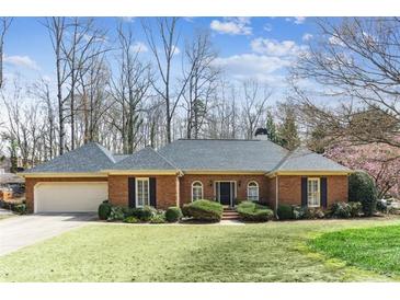 Charming brick home featuring a well-maintained lawn, two-car garage, and mature landscaping at 5270 Forest Brook Pkwy, Marietta, GA 30068