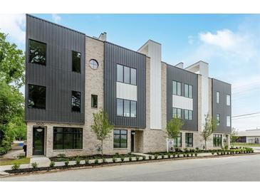 Modern townhome showcasing gray and white panels, light brick, well-maintained landscaping, and large windows at 1962 8Th St, Chamblee, GA 30341