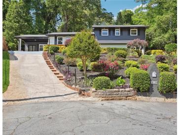 Inviting two-story home featuring a well-manicured front yard with colorful landscaping and a long driveway at 2139 Cedarbrook Court South East, Atlanta, GA 30316