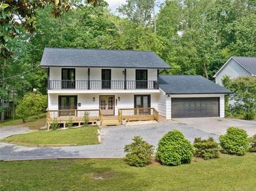 Charming two-story home with a gray roof, white siding and a well-maintained front yard at 4205 Mabry Ne Rd, Roswell, GA 30075