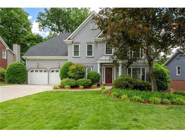 Charming two-story home with landscaped yard, a two-car garage, and a red front door at 4957 Day Lily Nw Way, Acworth, GA 30102
