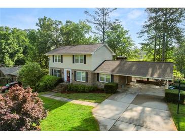 Charming two-story home with a brick facade, spacious driveway, well-manicured lawn, and inviting carport at 4379 Bonaparte Dr, Tucker, GA 30084